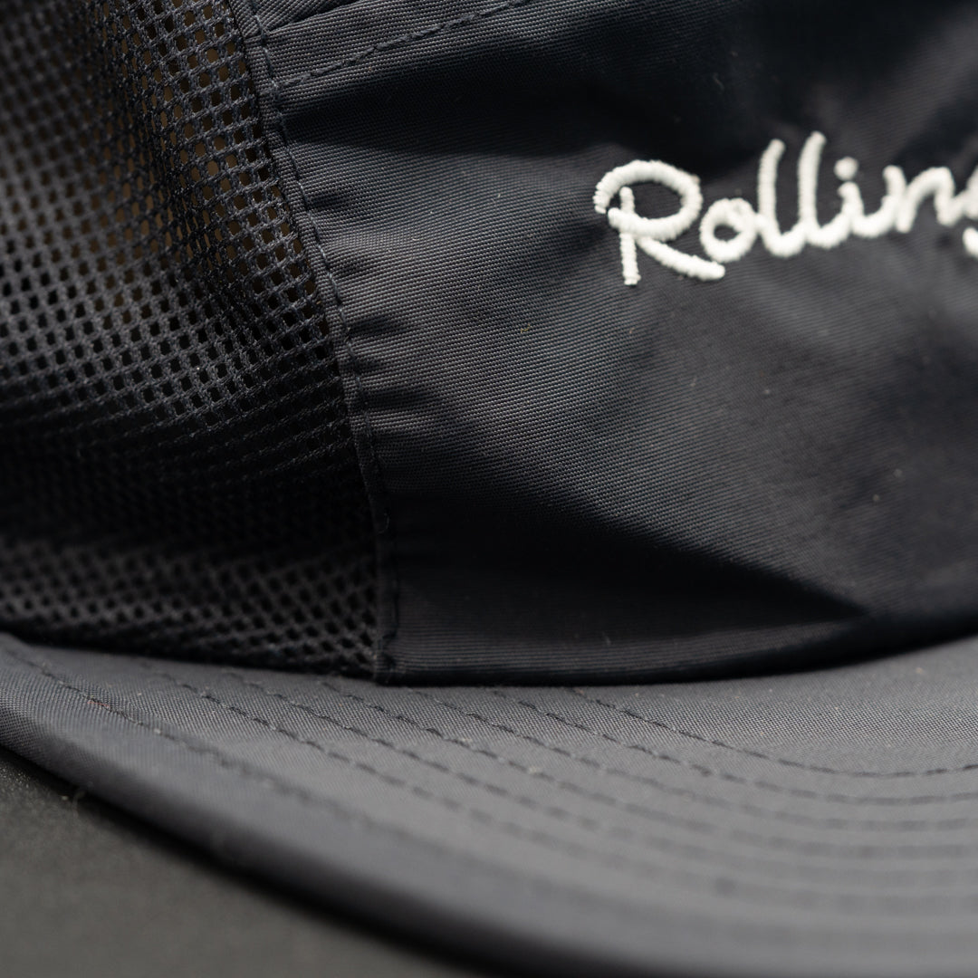 Detailed stitching for Rolling Waves Active 5-Panel Hat in dark blue with bone color designs, recycled nylon performance cap with mesh panels and UPF 50+ protection