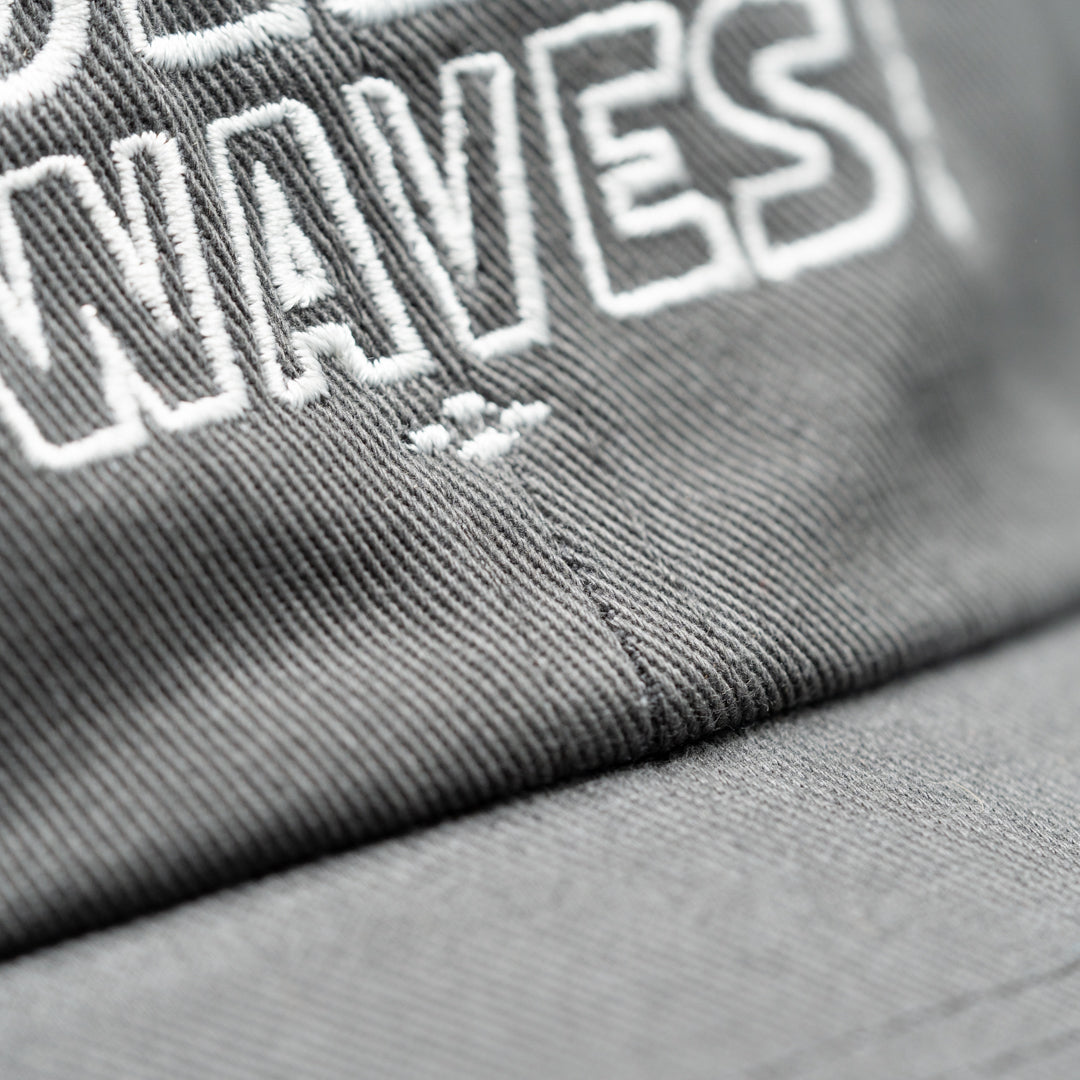 Detailed stitching for Rolling Waves Everyday Cap in dark grey with off-white block logo, garment-washed cotton twill unstructured cap with adjustable fit