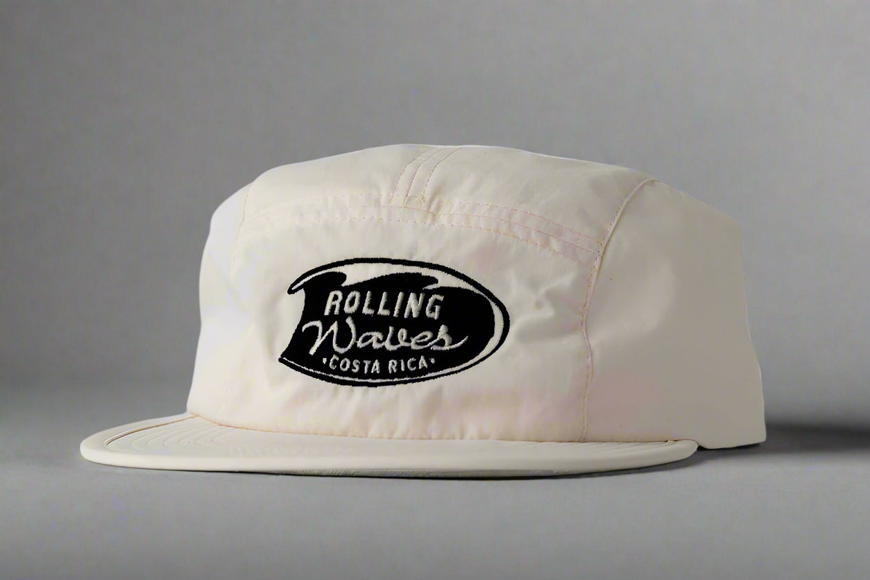 White cap with 'Rolling Waves Costa Rica' logo on a gray background