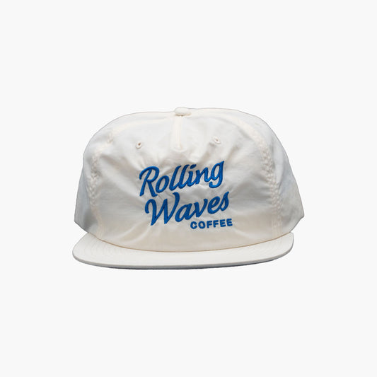 Front view of Rolling Waves OG Surf Cap in off-white with blue logo, recycled nylon unstructured snapback hat with UPF 50+ protection