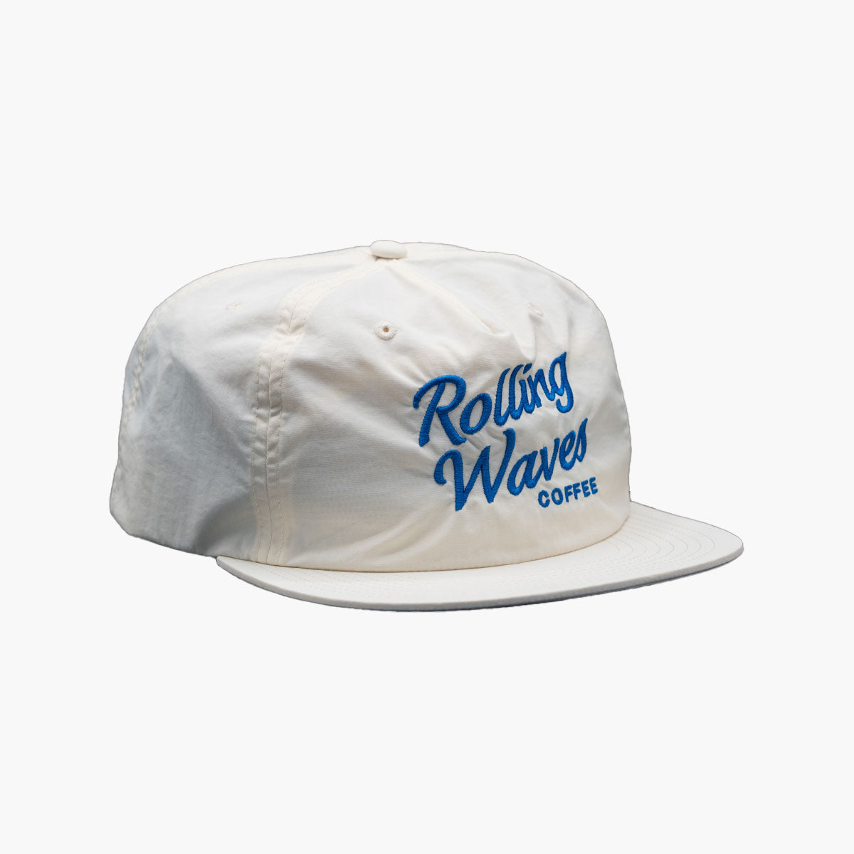 Side angle of Rolling Waves OG Surf Cap in off-white with blue logo, recycled nylon unstructured snapback hat with UPF 50+ protection